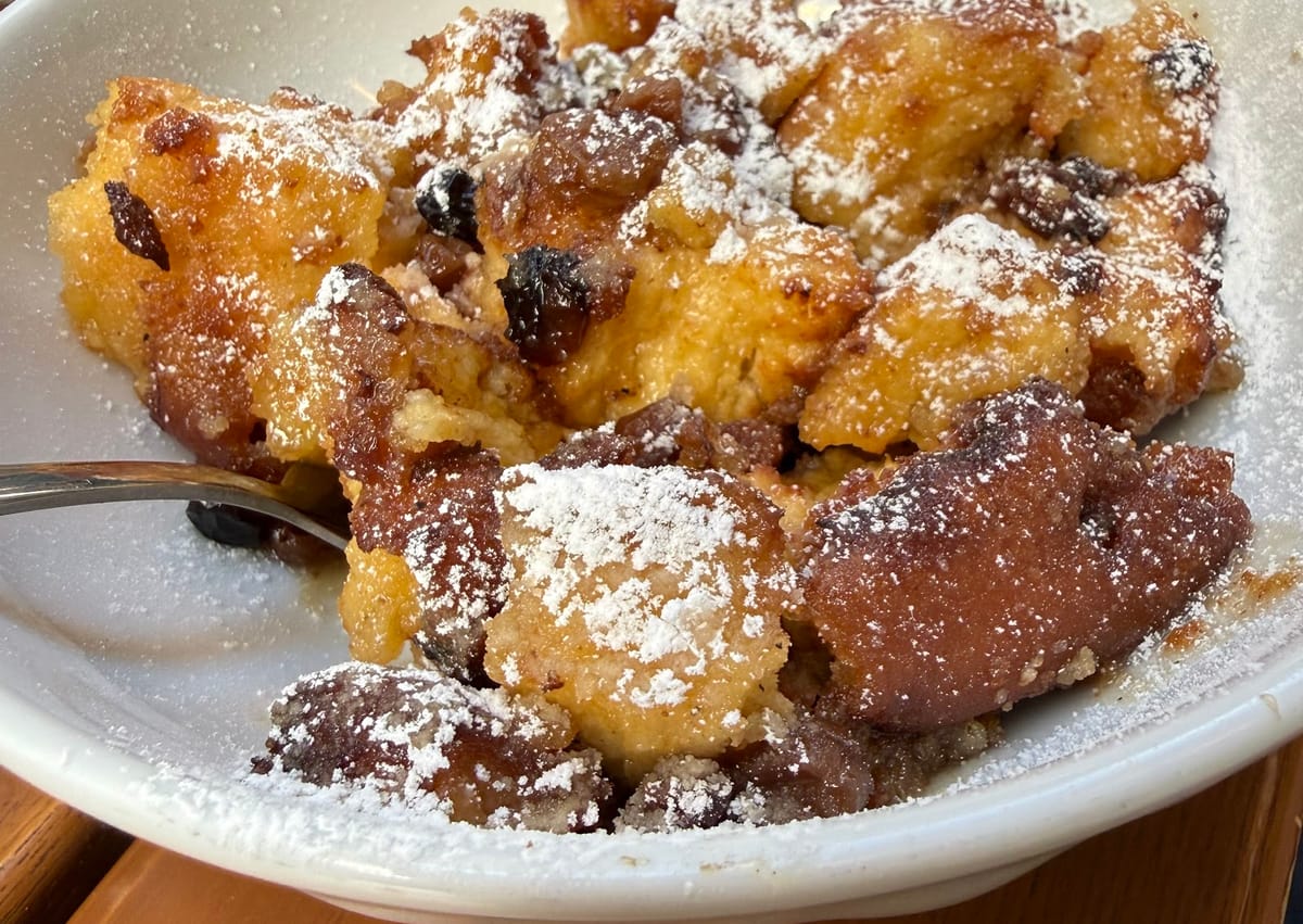 Kaiserschmarrn mit Staubzucker und Rosinen in einer weißen Schüssel